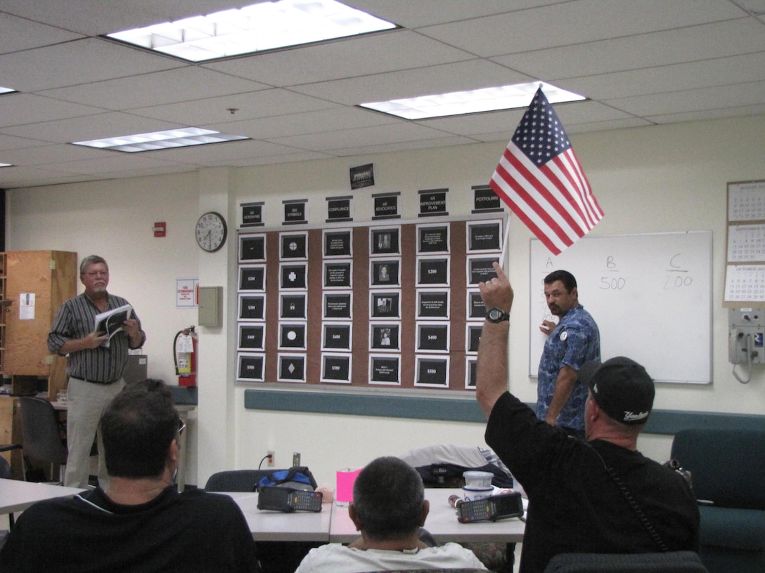 DLA Distribution San Joaquin Freight Terminal employees participate in Audit Readiness Jeopardy. The game aims to help employees to retain audit readiness knowledge in preparation for the upcoming Independent Public Accountant audit scheduled for 2016. Pictured, far left, is day shift supervisor Wayne Butler, game facilitator, and, standing on right, Freight Terminal Branch Chief Henry Martin, serving as score keeper.
