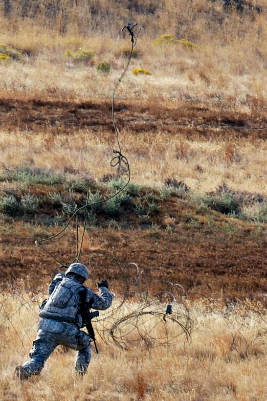 A U.S. soldier throws a grappling hook toward a wire obstacle during the culminating live-fire exercise of Exercise Rising Thunder at Yakima Training Center, Wash., Sept. 21, 2015. The U.S. soldier is assigned to the 2nd Infantry Division’s 4th Battalion, 23rd Infantry Regiment, 2nd Stryker Brigade. U.S. Army photo by Sgt. Eliverto Larios