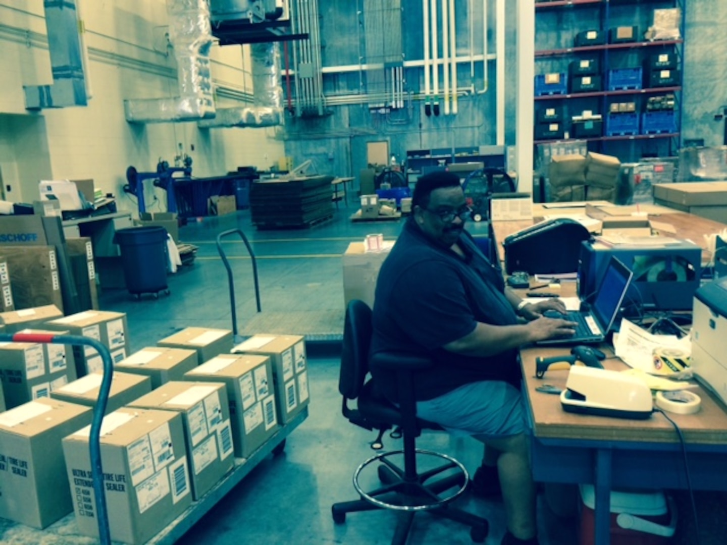 Eugene Harris works at his computer in the packing section at DLA Distribution Jacksonville, Fla., at Gulfport, Miss.