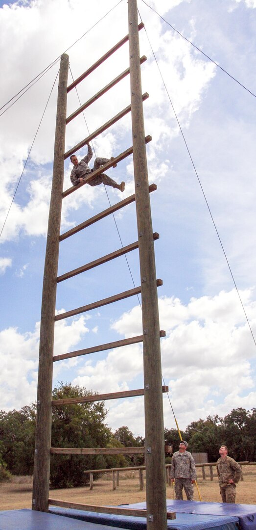 A medic watches his teammate climb the ladder on the obstacle course as evaluators watch during the Southern Regional Medical Command Best Medic Competition at Camp Bullis Sept. 19. The first medic must be coming down the ladder before the second medic can begin their climb. Competitors have three chances to complete an obstacle before receiving a penalty.
