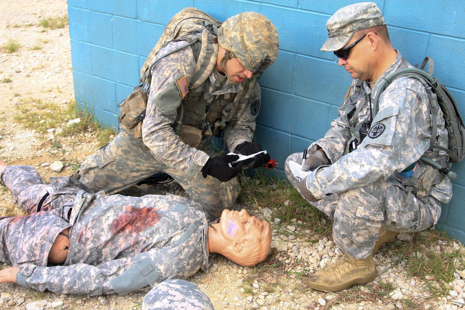 Army Sgt. Eric Pasman (left), Bayne-Jones Army Community Hospital, Fort Polk, La., triages a simulated casualty and provides battlefield aid during the Southern Regional Medical Command Best Medic Competition at Camp Bullis Sept. 18-20. An evaluator looks on and scores the correctness of the procedures.