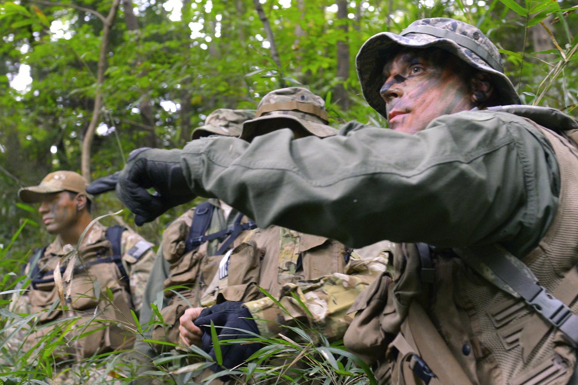 Participants in the survival, evasion, resistance and escape combat survival training, plan their first move at Tama Hills Recreation Area, Japan, Sept. 24, 2015. SERE training keeps personnel prepared for contingency situations, such as evading and escaping capture behind enemy lines. (U.S. Air Force photo/Airman 1st Class Elizabeth Baker)