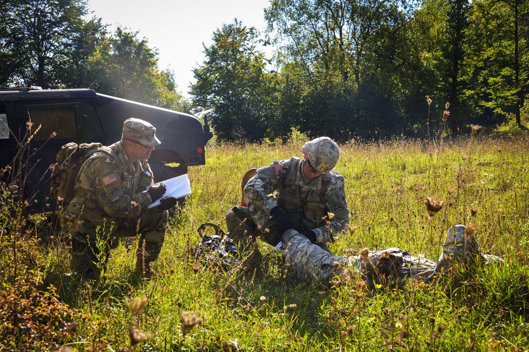 U.S. Army Expert Infantryman Badge candidate Sgt. Domanecke Pickens, center, performs first aid to a simulated casualty during the Joint Multinational Readiness Center's Expert Infantryman Badge Competition at the Hohenfels Training Area, Germany, Sept. 29, 2015. U.S. Army photo by Markus Rauchenberger