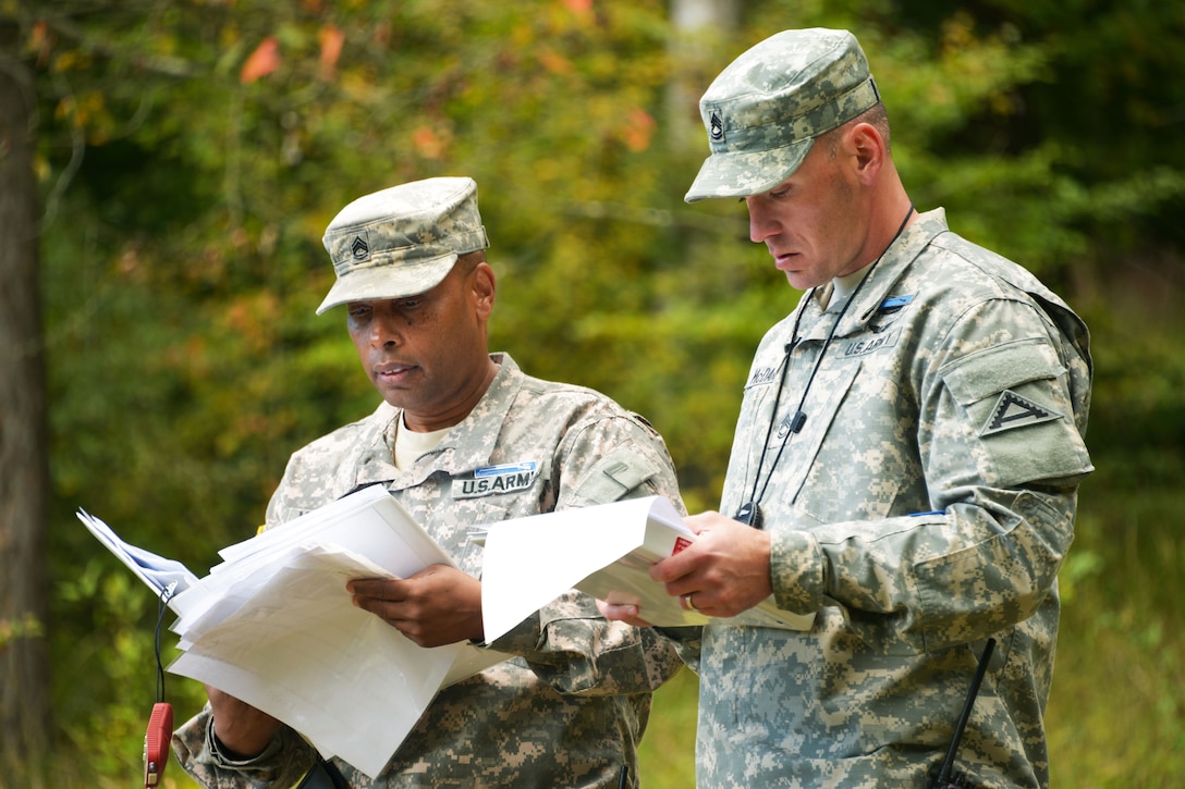 U.S. Army Expert Infantryman Badge lane evaluators, stationed on the Joint Multinational Readiness Center check a candidate's record during the  competition on the Hohenfels Training Area, Germany, Sept. 29, 2015. U.S. Army photo by Markus Rauchenberger