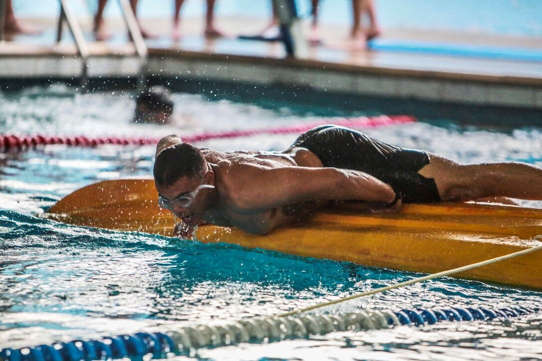 BASE AERIENNE 188, Djibouti (Sept. 22, 2015) U.S. Marine Lance Cpl. Brandon Satariano swims over a kayak as part of an obstacle during the swim portion of an indoctrination prior to participating in a desert survival course. Satariano is a light armored vehicle crewman with Delta Company, Light Armored Reconnaissance Detachment, 15th Marine Expeditionary Unit. Elements of the 15th MEU are training with the 5th RIAOM in Djibouti in order to improve interoperability between the MEU and the French military. (U.S. Marine Corps photo by Sgt. Steve H. Lopez/Released)