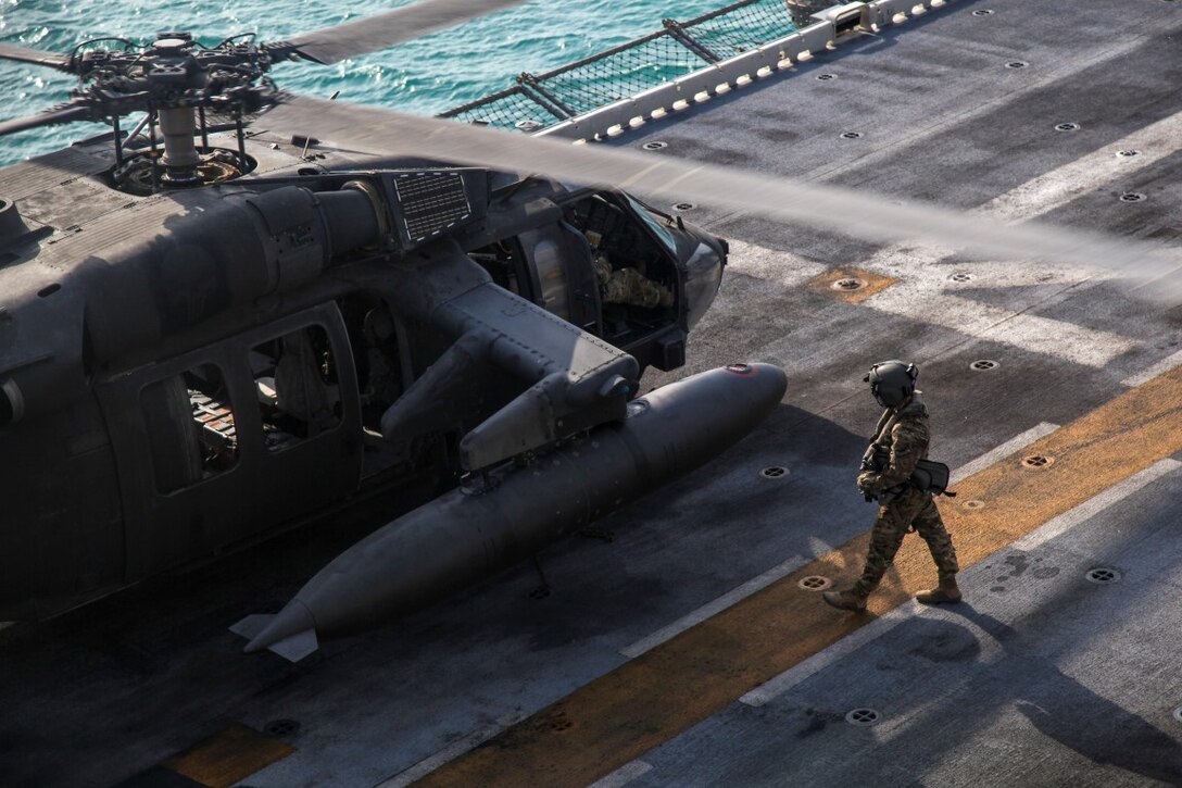 ARABIAN GULF (Sept. 29, 2015) A U.S. Soldier with the 185th Theater Aviation Brigade walks toward a UH-60 Black Hawk aboard the amphibious assault ship USS Essex (LHD 2). These Soldiers practiced landing and departing from the Essex in order to familiarize themselves with flight operations aboard a ship. The 15th Marine Expeditionary Unit, embarked aboard the ships of the Essex Amphibious Ready Group, is deployed to maintain regional security in the U.S. 5th Fleet area of operations. (U.S. Marine Corps photo by Cpl. Elize McKelvey/Released)