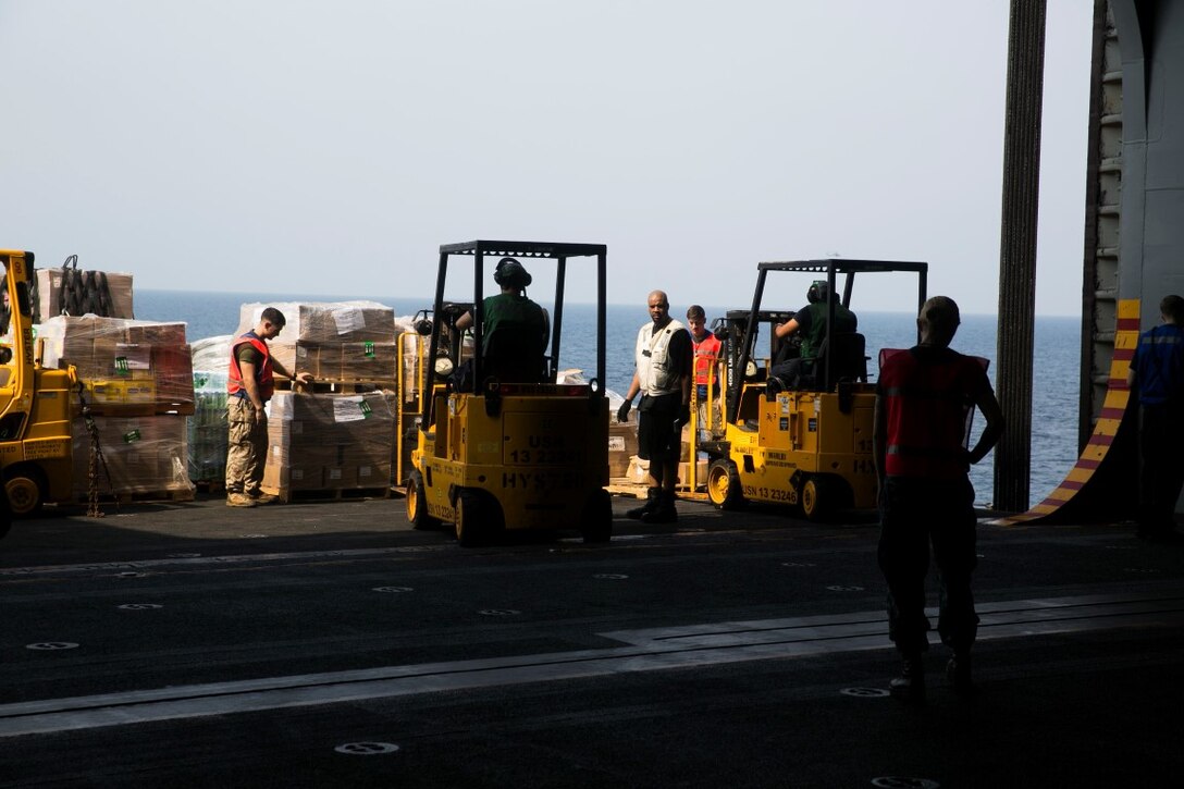 ARABIAN GULF (Sept. 29, 2015) U.S. Marines with the 15th Marine Expeditionary Unit and Sailors move pallets during a replenishment-at-sea aboard the amphibious assault ship USS Essex (LHD 2). Marines and Sailors worked together to sort through the food, equipment, and mail they received during the RAS. The 15th Marine Expeditionary Unit, embarked aboard the ships of the Essex Amphibious Ready Group, is deployed to maintain regional security in the U.S. 5th Fleet area of operations. (U.S. Marine Corps photo by Cpl. Anna Albrecht/Released)