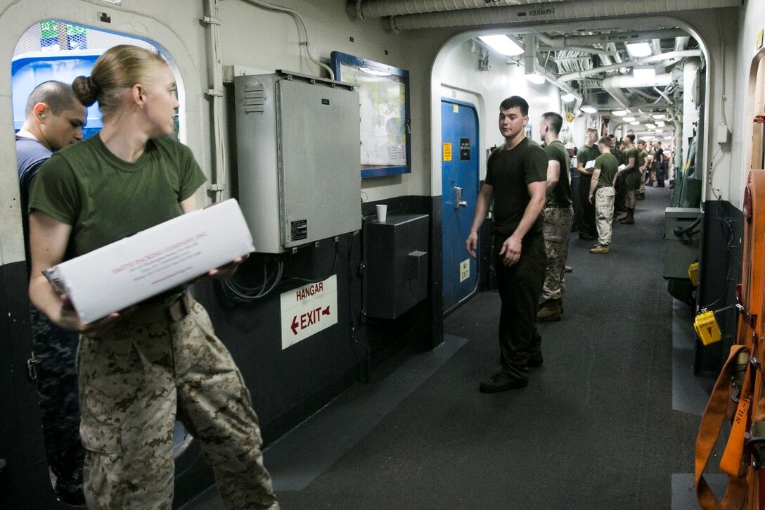 ARABIAN GULF (Sept. 29, 2015) U.S. Marines and Sailors with the 15th Marine Expeditionary Unit help out during a replenishment-at-sea aboard the amphibious assault ship USS Essex (LHD 2). Marines and Sailors worked together to sort through the food, equipment, and mail they received during the RAS. The 15th Marine Expeditionary Unit, embarked aboard the ships of the Essex Amphibious Ready Group, is deployed to maintain regional security in the U.S. 5th Fleet area of operations. (U.S. Marine Corps photo by Cpl. Anna Albrecht/Released)