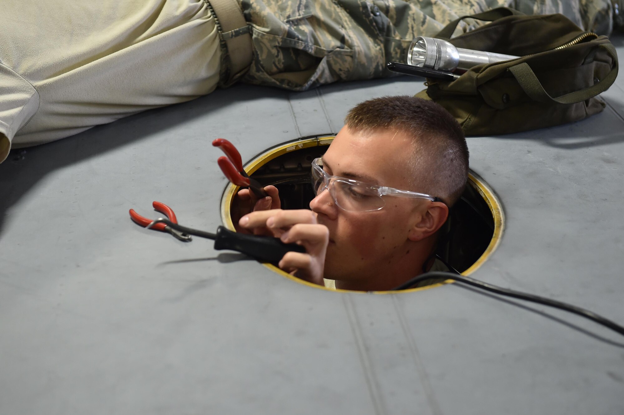 Staff Sgt. Mike Fisher, a crew chief for the 910th Maintenance Squadron, grabs a tool while working in in the area behind one of the engines of a C-130H Hercules aircraft during an isochronal inspection here, Sept. 12, 2015. Isochronal inspections are performed every 540 days to check areas of the aircraft that are not covered during routine inspections on the flight line. (U.S. Air Force photo/Tech. Sgt. Jim Brock)
