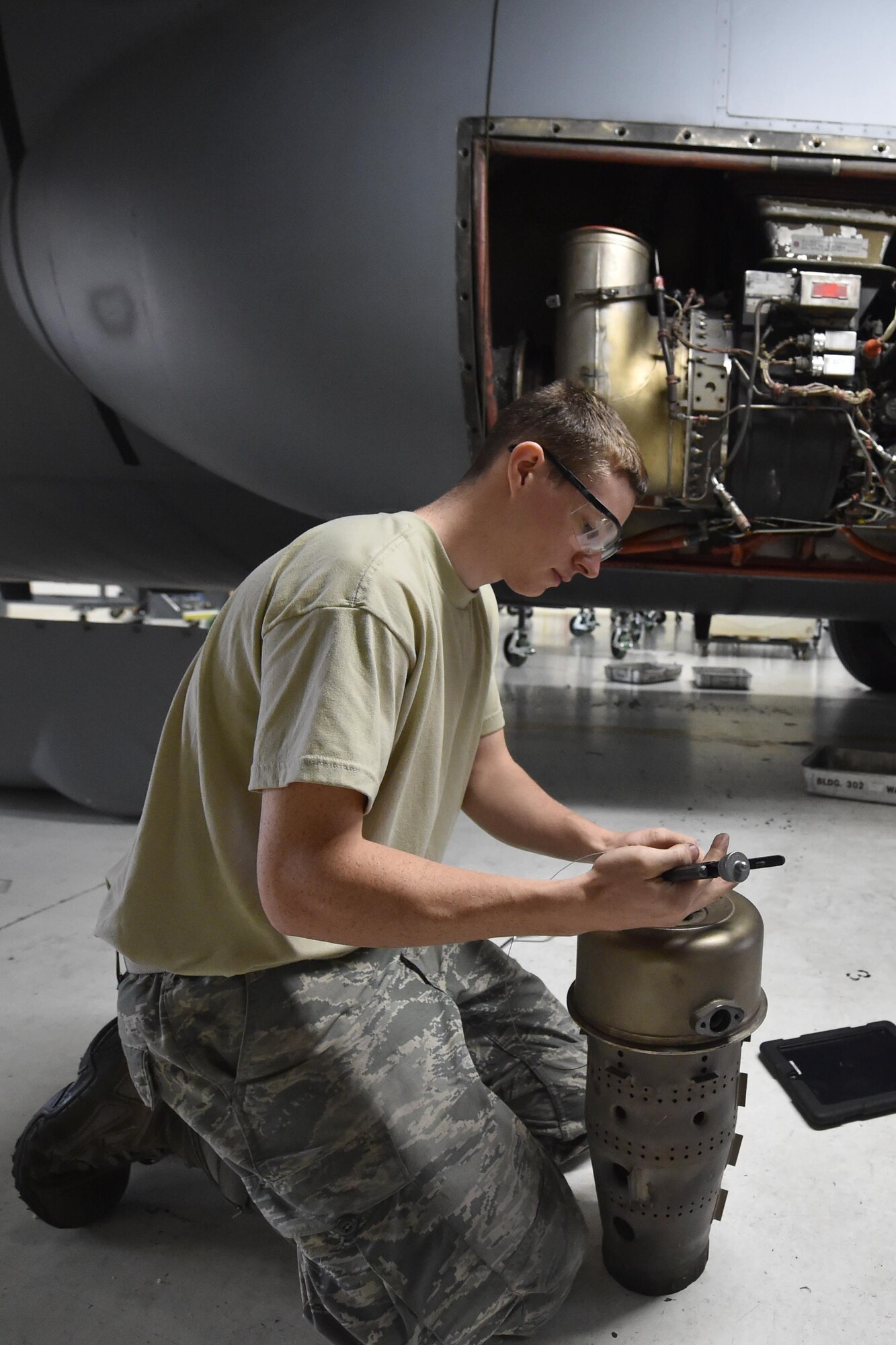 Staff Sgt. Mike Fisher, a crew chief for the 910th Maintenance Squadron, grabs a tool while working in in the area behind one of the engines of a C-130H Hercules aircraft during an isochronal inspection here, Sept. 12, 2015. Isochronal inspections are performed every 540 days to check areas of the aircraft that are not covered during routine inspections on the flight line. (U.S. Air Force photo/Tech. Sgt. Jim Brock)
