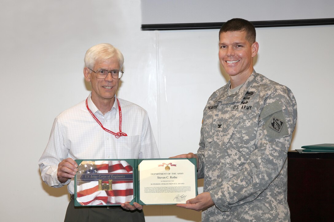 Steve Rothe (left), Omaha District Project Manager, receives the Superior Civilian Service Award from Omaha District Commander Colonel John Henderson (right) upon his retirement after nearly 40 years of public service. 