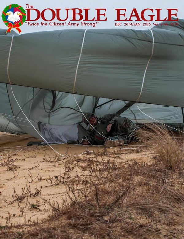 COVER STORY: Pfc. William Thompson lands at Sicily Drop Zone during the 17th Annual Randy Oler Memorial Operation Toy Drop, hosted by the U.S. Army Civil Affairs & Psychological Operations Command (Airborne), a U.S. Army Reserve operational command, Dec. 6, 2014 at Fort Bragg, N.C. Thompson serves in the 319th Airborne Field Artillery Regiment, 82nd Airborne Division. Thousands of paratroopers donated new, unwrapped toys to earn a seat for a jump and the chance to earn jump wings from one of six allied nations participating in this year’s event. (Photo by Timothy L. Hale/U.S. Army Reserve Command)