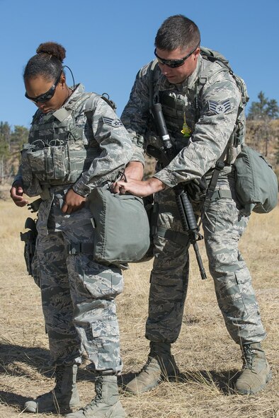 U.S. Air Force Staff Sgt. Paul Downs helps Senior Airman Malachia Jones get ready for the Mental and Physical Challenge on Sept. 22, 2015, Camp Guernsey Joint Training Center, Wyo. Downs and Jones are assigned to the Air Force Reserve Command’s 307th Security Forces Squadron at Barksdale Air Force Base, La. (U.S. Air Force photo by Master Sgt. Greg Steele/Released)