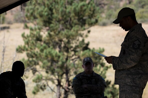 An Air Force Global Strike Command Challenge controller reads the rules for the Mental and Physical (MAP) Challenge on Sept. 22, 2015, Camp Guernsey Joint Training Center, Wyo. The MAP Challenge is a timed event, where Security Forces teams use their land navigation skills to reach check points, testing their team work and ability to complete objectives under harsh and stressful conditions. (U.S. Air Force photo by Master Sgt. Greg Steele/Released)