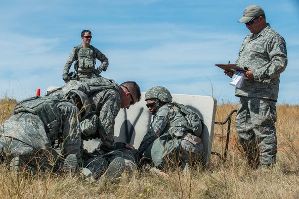 Members of the 307th Security Forces Squadron competition team perform Self-Aid and Buddy Care techniques on a simulated injured Airman during the Mental and Physical (MAP) Challenge on Sept. 22, 2015, Camp Guernsey Joint Training Center, Wyo. The MAP Challenge is a timed event, where Security Forces teams use their land navigation skills to reach check points, testing their team work and ability to complete objectives under harsh and stressful conditions. (U.S. Air Force photo by Master Sgt. Greg Steele/Released)