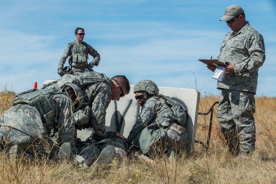 Members of the 307th Security Forces Squadron competition team perform Self-Aid and Buddy Care techniques on a simulated injured Airman during the Mental and Physical (MAP) Challenge on Sept. 22, 2015, Camp Guernsey Joint Training Center, Wyo. The MAP Challenge is a timed event, where Security Forces teams use their land navigation skills to reach check points, testing their team work and ability to complete objectives under harsh and stressful conditions. (U.S. Air Force photo by Master Sgt. Greg Steele/Released)