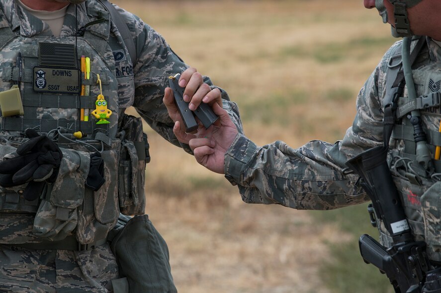 Members of the 307th Security Forces Squadron pass around ammunition before the start of the Weapons Firing Challenge on Sept. 23, 2015, Camp Guernsey Joint Training Center, Wyo. The challenge consists of teams being evaluated on their marksmanship using the M4 rifle, M9 pistol, M240 machine gun and the M203 grenade launcher. (U.S. Air Force photo by Master Sgt. Greg Steele/Released)