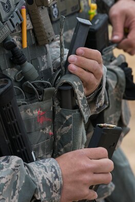 Members of the 307th Security Forces Squadron pass around ammunition before the start of the Weapons Firing Challenge on Sept. 23, 2015, Camp Guernsey Joint Training Center, Wyo. The challenge consists of teams being evaluated on their marksmanship using the M4 rifle, M9 pistol, M240 machine gun and the M203 grenade launcher. (U.S. Air Force photo by Master Sgt. Greg Steele/Released)