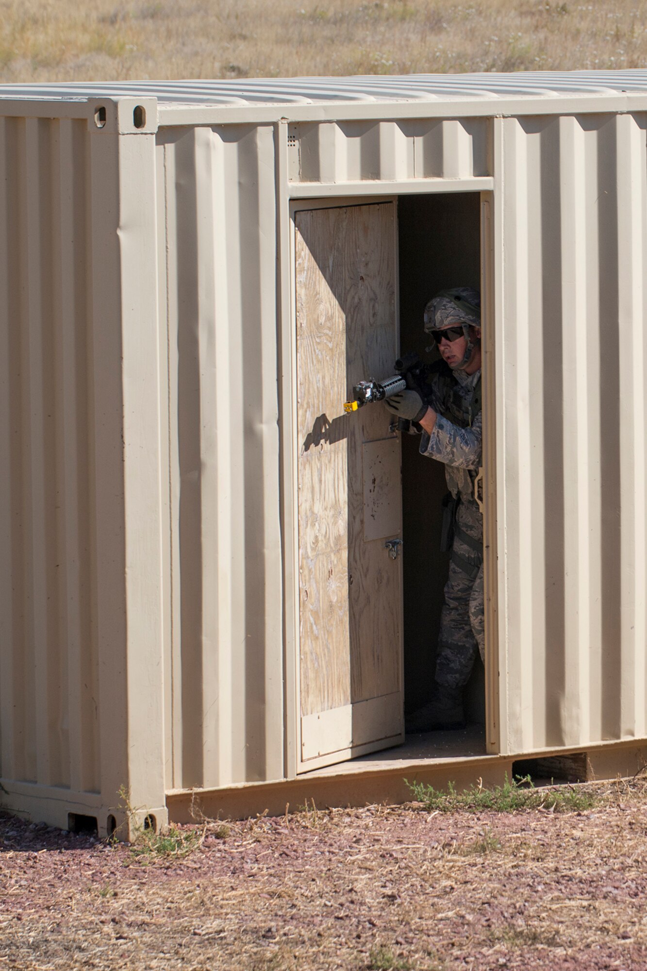 A member of the 307th Security Forces Squadron peers out of a doorway during the Capture and Recovery Challenge on Sept. 24, 2015, Camp Guernsey Joint Training Center, Wyo. The challenge consists of teams eliminating enemy threats and securing a nuclear asset. (U.S. Air Force photo by Master Sgt. Greg Steele/Released)