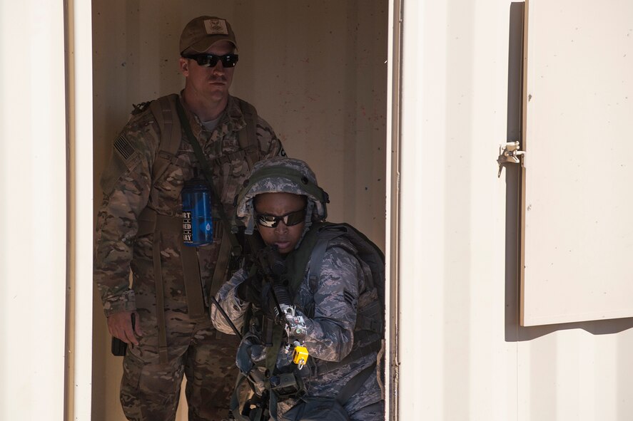 Under the watchful eye of an evaluator, U.S. Air Force Senior Airman Malachia Jones, 307th Security Forces Squadron, makes her way through a compound during the Capture and Recovery Challenge on Sept. 24, 2015, Camp Guernsey Joint Training Center, Wyo. The challenge consists of teams eliminating enemy threats and securing a nuclear asset. (U.S. Air Force photo by Master Sgt. Greg Steele/Released)