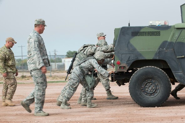 Members of the 307th Security Forces Squadron push a HUMVEE as part of the Warrior Run Challenge on Sept. 25, 2015, Camp Guernsey Joint Training Center, Wyo. The challenge consists of a team run, a HUMVEE push and a buddy carry through the finish line. (U.S. Air Force photo by Master Sgt. Greg Steele/Released)