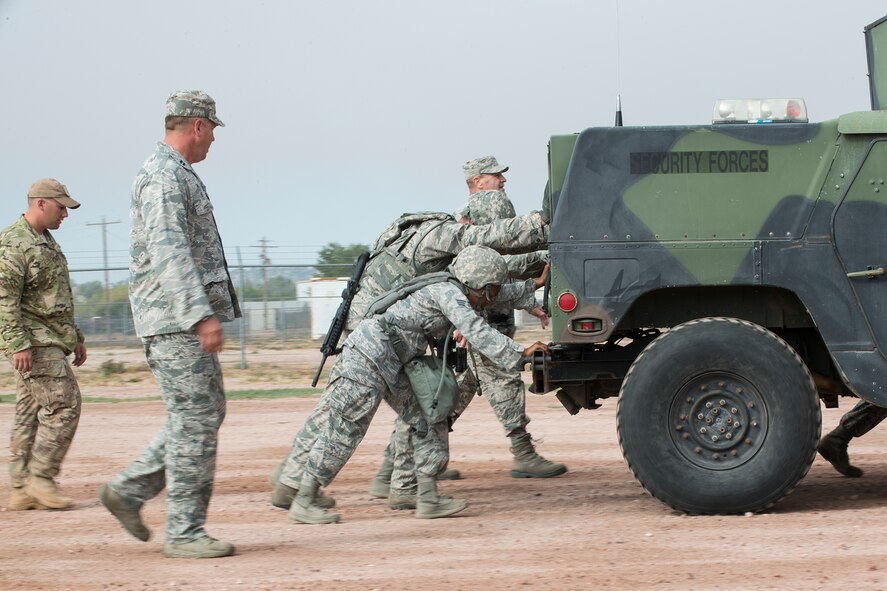 Members of the 307th Security Forces Squadron push a HUMVEE as part of the Warrior Run Challenge on Sept. 25, 2015, Camp Guernsey Joint Training Center, Wyo. The challenge consists of a team run, a HUMVEE push and a buddy carry through the finish line. (U.S. Air Force photo by Master Sgt. Greg Steele/Released)