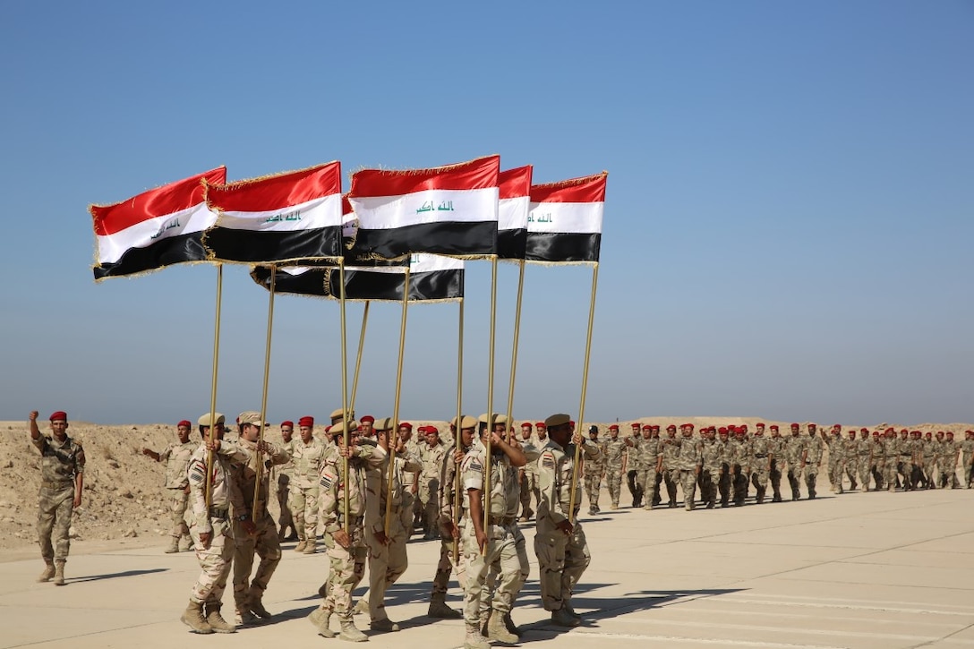 Members of the Popular Mobilization Program march in formation with Iraqi national flags during a graduation ceremony at Al Taqaddum Air Base, Iraq, Sept. 3, 2015. The Popular Mobilization Program is an Iraqi-led, Operation Inherent Resolve program that trains volunteer tribal forces in leadership, small unit tactics and urban warfare to ultimately serve with Iraqi Security Forces in their battle to defeat the Islamic State of Iraq and the Levant and ensure the safety and security of its citizens. (U.S. Marine Corps photo by Cpl. John Baker / released)