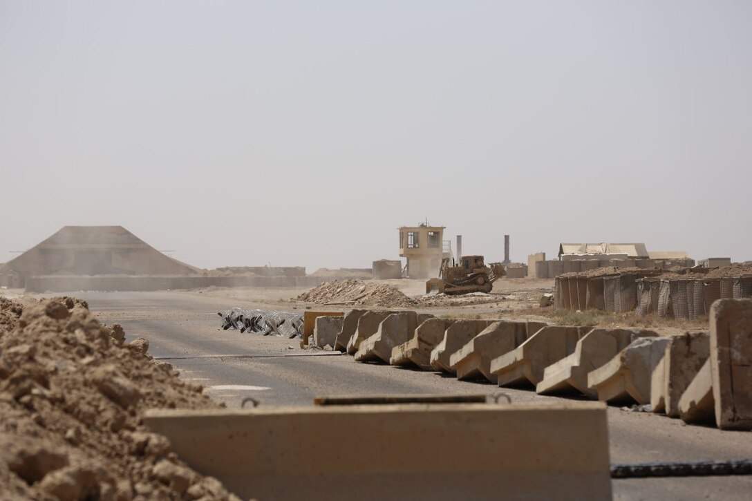 A U.S. Marine bulldozer works to build a defensive berm to enhance the perimeter of Camp Manion, Iraq, Aug. 20, 2015.  Located on Al Taqaddum, Air Base, the camp is named after Marine 1st Lt. Travis Manion, who was killed in action in Anbar province in 2007. Coalition personnel reestablished a presence there in June 2015 to advise and assist the Iraqi security forces. By pairing experienced personnel with their Iraqi counterparts, coalition forces can provide intelligence, logistics and operations planning support to ultimately enable the Iraqi security forces to defeat the Islamic State of Iraq and the Levant. (U.S. Marine Corps photo by Cpl. John Baker/released)