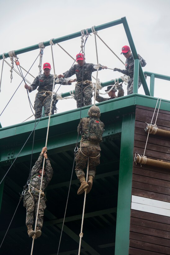 U.S. Marine Lance Cpl. Crosby, bottom right, races up a rope tower during a company competition at Korea Marine Exchange Program 15-12 at Yooghuk Dae, Munseu San Mountain, Republic of Korea, Sept. 11, 2015. The U.S. and ROK Marines competed for the fastest integrated company in rappelling, rocking climbing and rope climbing before a sprint to the finish line. KMEP 15-12 is a bilateral training exercise that enhances the ROK and U.S. alliance, promotes stability on the Korean Peninsula and strengthens ROK and U.S. military capabilities and interoperability. Crosby, from Glendale, Arizona, is a rifleman with Fox Company, 2nd Battalion, 3rd Marine Division and attached through the Unit Deployment Program to III Marine Expeditionary Force. The ROK Marines are with 11th Battalion, 1st Regiment, 2nd Marine Division, ROK Headquarters Marine Corps.