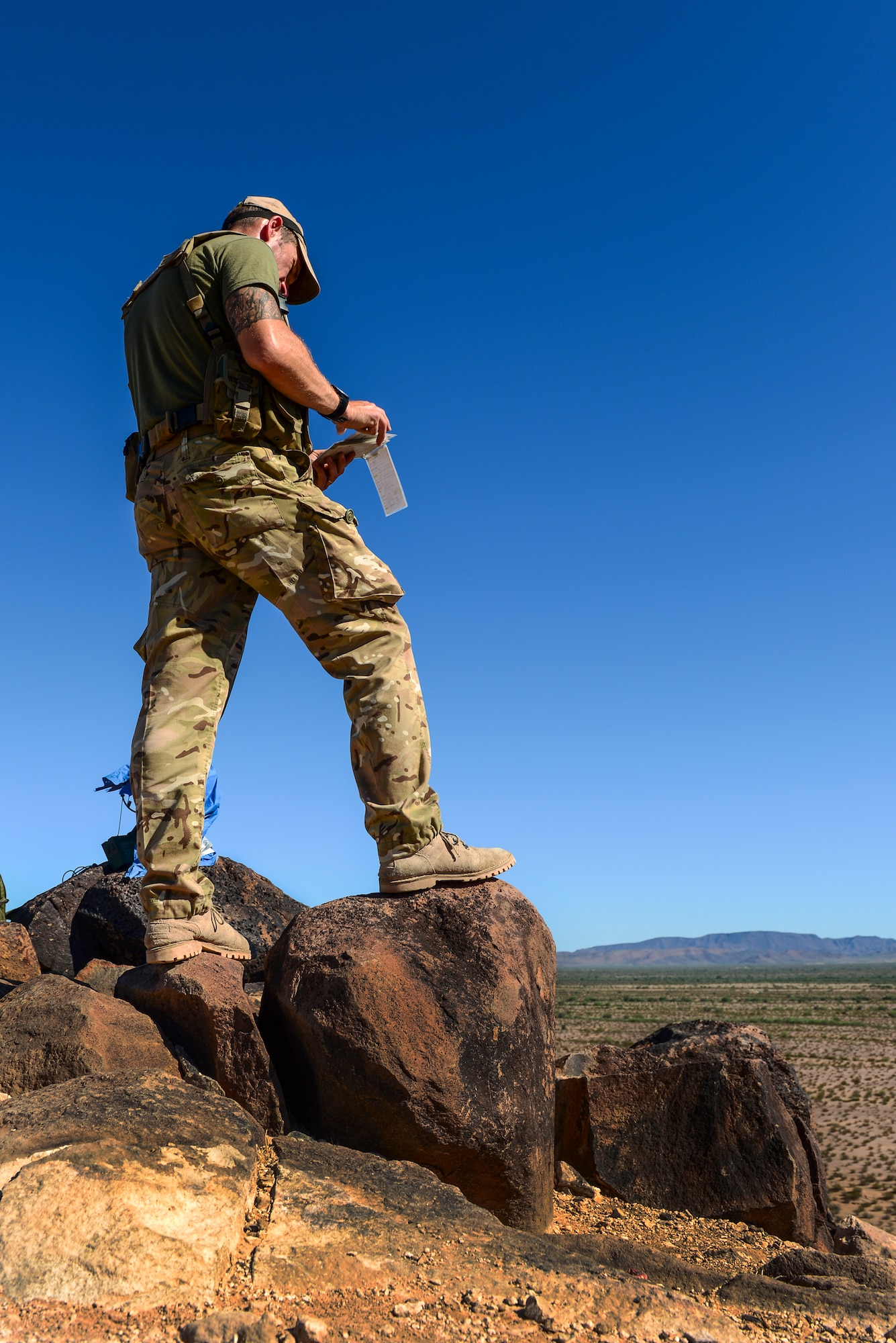British Army Warrant Officer Class 2 Mark Sutherington, Royal Horse Artillery joint tactical air controller, scans through a notepad containing target information at Barry M. Goldwater Range, Ariz., Sept. 23, 2015. JTACs relay information to pilots such as target location, threat type and ordnance delivery to eliminate enemy forces. (U.S. Air Force photo by Airman 1st Class Chris Drzazgowski/Released)