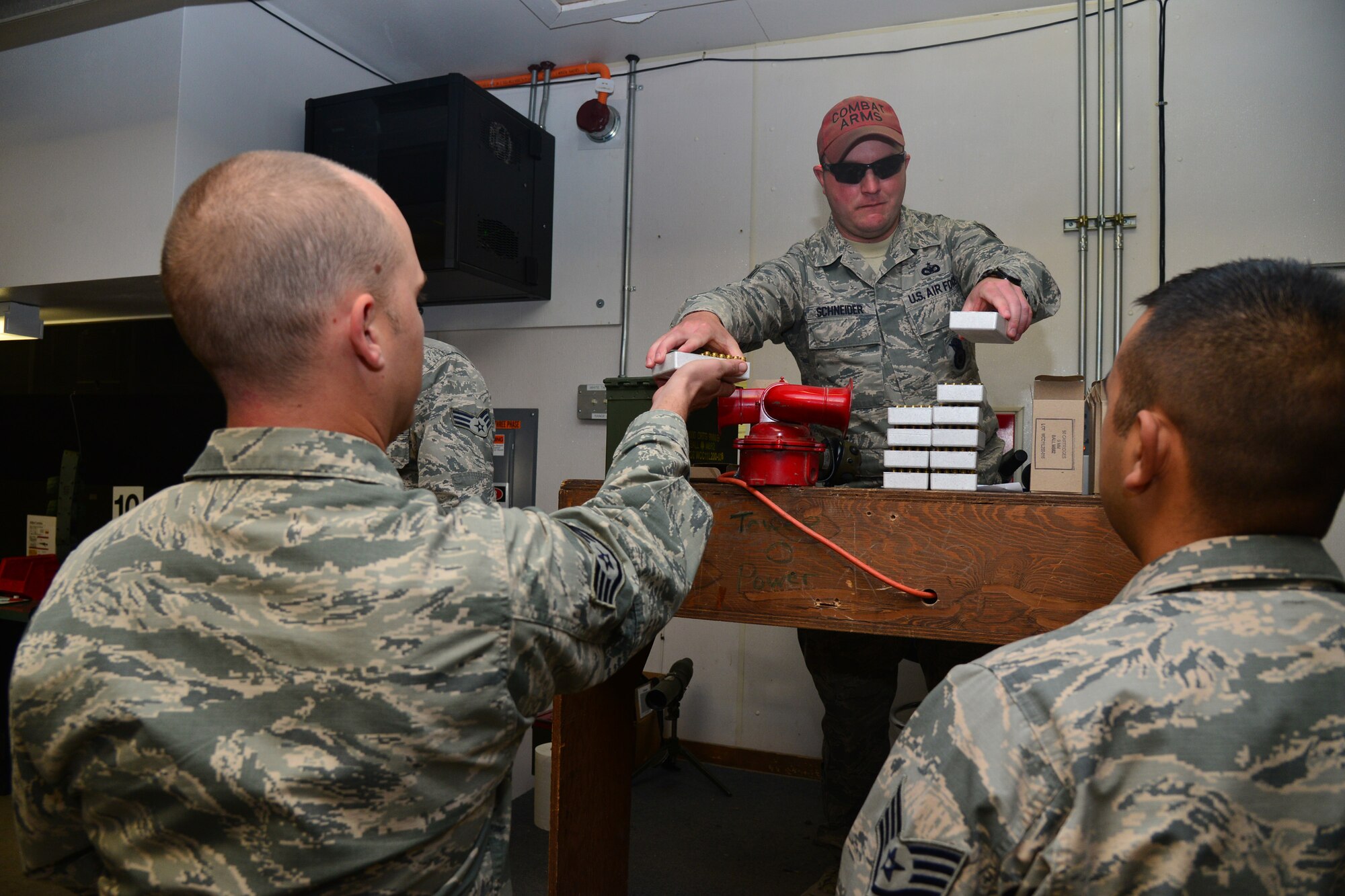 Tech. Sgt. Rayce Schneider, 341st Security Support Squadron NCO in charge of combat arms, provides ammunition to competitors before the start of an Excellence in Competition Marksman Event, held at the base firing range Sept. 28-29 at Malmstrom Air Force Base, Mont. All competitors were given 30 rounds of ammunition to use throughout three rounds of shooting. (U.S. Air Force photo/Airman Daniel Brosam)