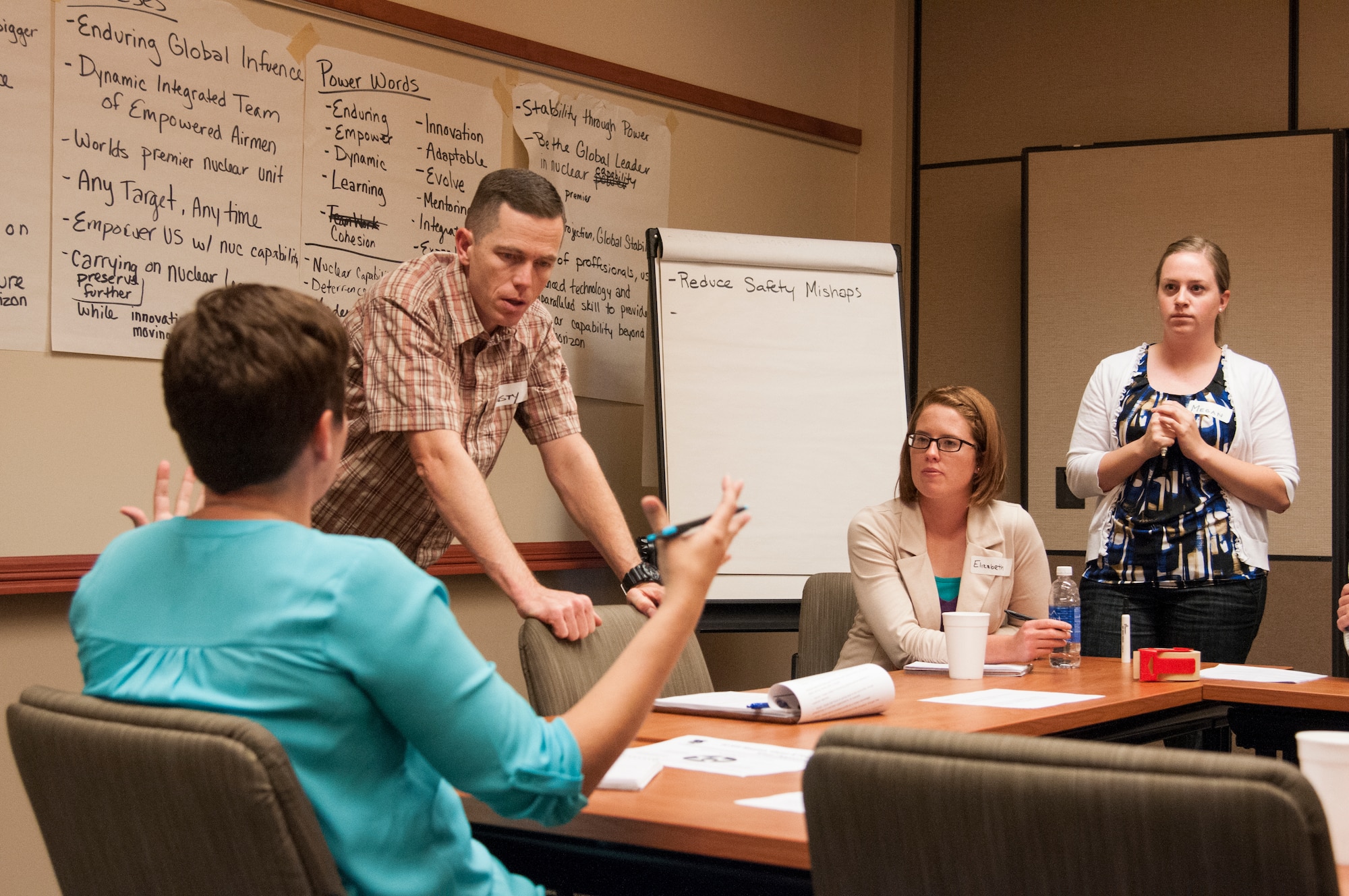 Lt. Col. Russell Williford, 320th Missile Squadron commander, and Airmen discuss potential new wing goals at an “off-site” in the Army Aviation Support Facility on F.E. Warren Air Force Base, Wyo.,Sept. 9, 2015. The off-site gave Airmen the chance to participate in large-group and small-group discussions to create a new wing vision and new wing goals. (U.S. Air Force photo by Senior Airman Jason Wiese)