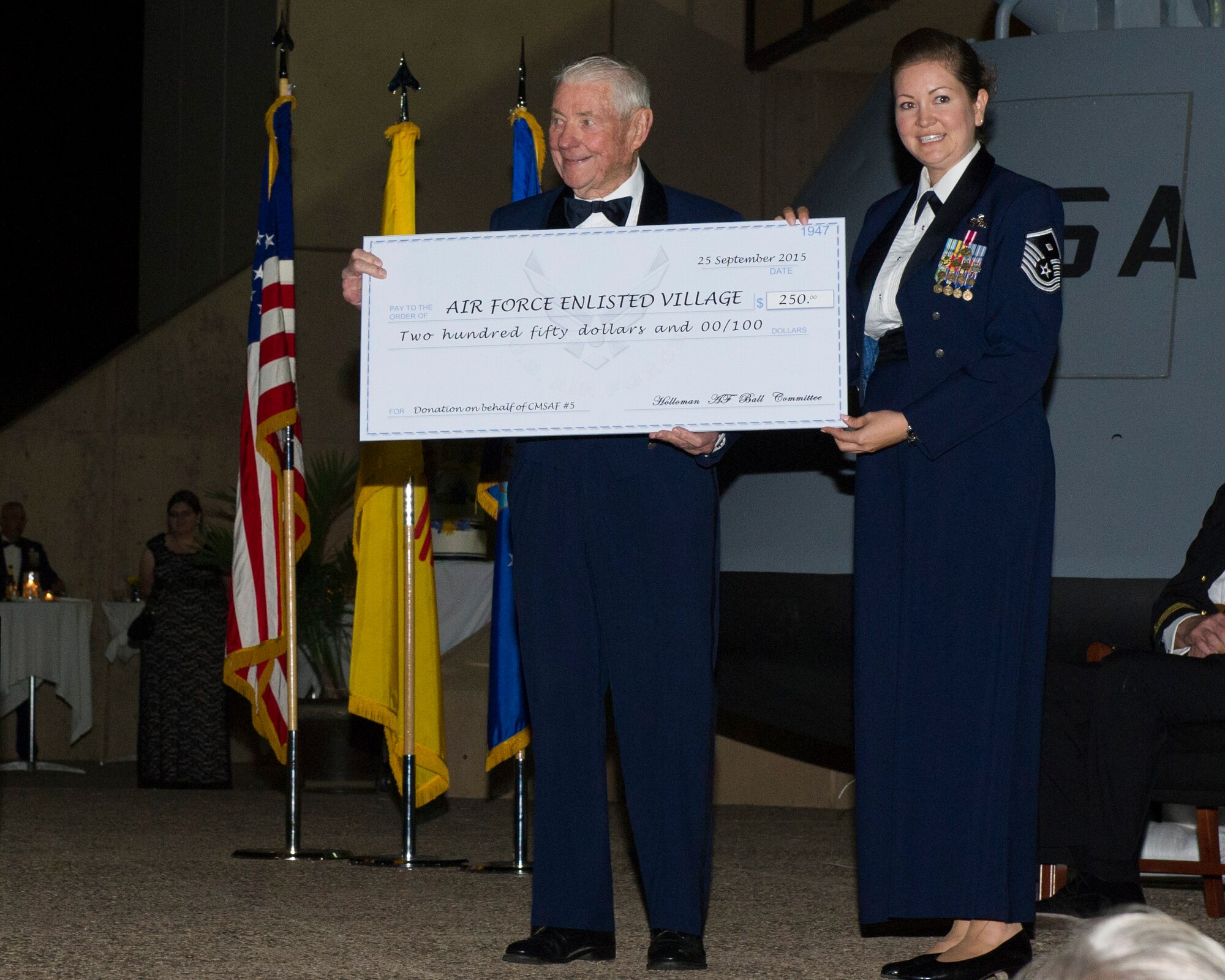 Robert Gaylor, fifth Chief Master Sergeant of the Air Force, accepts a check for the Air Force Enlisted Village after his presentation at the 68th Air Force Ball on Sept. 25. Gaylor is on the board of directors for the Air Force Enlisted Village. The mission of the Air Force Enlisted Village is to provide safe and secure housing to spouses of retired enlisted U.S. Airmen.  