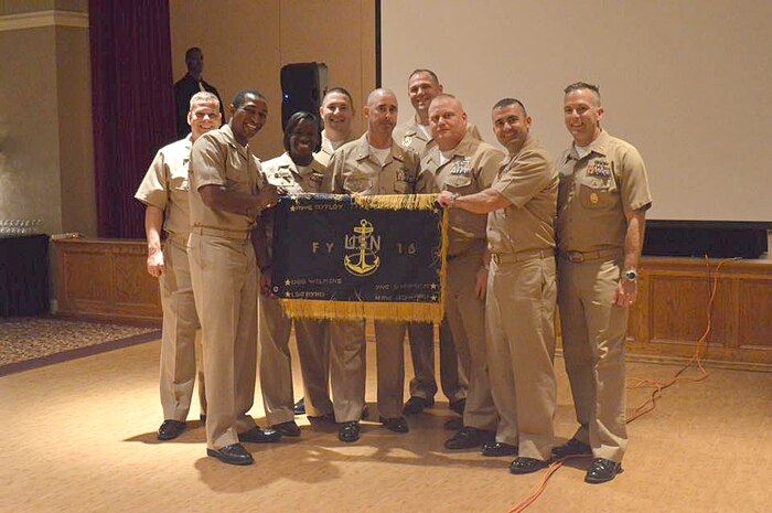 (left to right) Logistic Specialist Chief Petty Officer Chris Byrd, Mineman Chief Petty Officer David Toyloy, Yeoman Chief Petty Officer Ashely Cooper, Master-at-Arms Chief Petty Officer Rick Crowell, Command Master Chief Jason Roach, Fire Controlman Chief Petty Officer Rob McElroy, Command Master Chief Joe Gardner, Electrician’s Mate Chief Petty Officer Thomas Byers, and Command Master Chief Bob Williamson pose for a group photo during this year’s Khaki Ball held at the Redbank Club, Joint Base Charleston – Weapons Station, Sept. 26, 2015. The event is held throughout the U.S. Navy each year to welcome the newly pinned Chiefs, their spouses and significant others into the Chiefs Mess. One of the proudest days in a Sailor’s life is the date when he or she dons the khaki uniform. (Courtesy Photo)