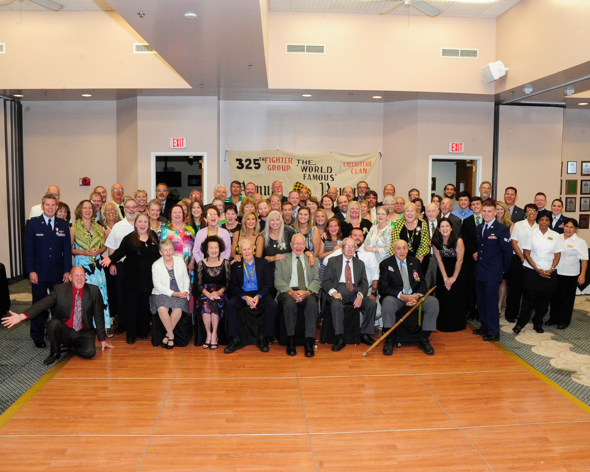 Members of the 325th Fighter Group and those in attendance pose for a photo Sept. 26 at the Checkertail Reunion. The 325th Fighter Wing hosted the 70th Annual Reunion of the World War II Fighter Group, the Checkertail Clan. The reunion, held at Tyndall, honored guests of the current 325th FW. The Checkertail reunion featured a welcome reception, memorabilia show, a tour of Tyndall, a “Black and Gold” banquet and a premiere of Checkertail documentaries.  (U.S. Air Force photo by Airman 1st Class Solomon Cook/ Released)

