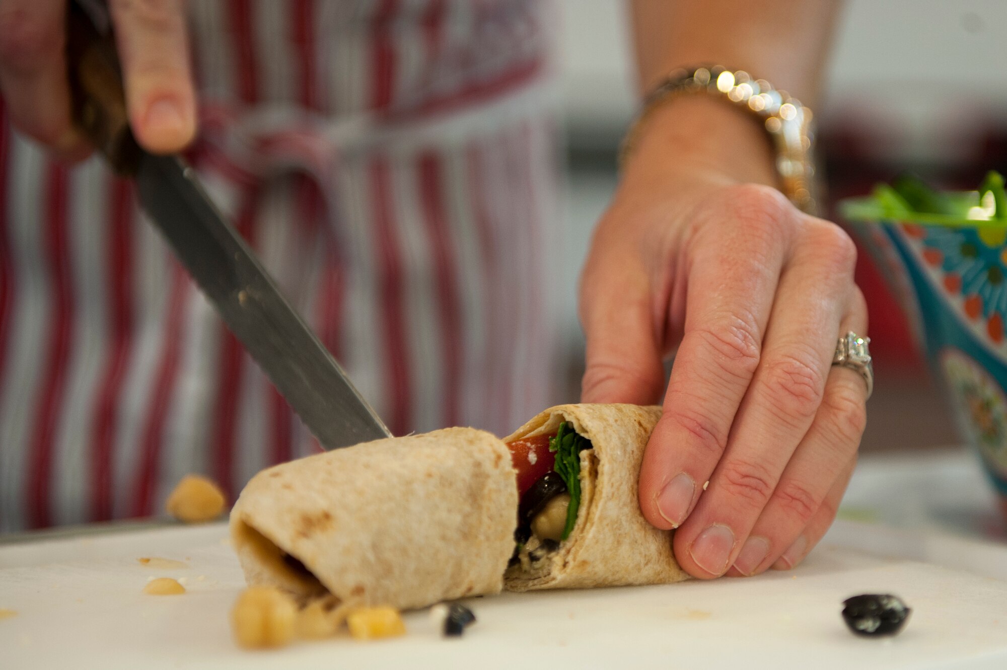 Erin Locke, 23d Medical Group health promotion dietitian, cuts a Mediterranean chick pea wrap during a healthy eating class for Super Sports Day Sept. 29, 2015, at Moody Air Force Base, Ga. Locke provided attendees with recipes and healthy eating material in support of the physical domain of Comprehensive Airmen Fitness. (U.S. Air Force photo by Airman 1st Class Kathleen D. Bryant/Released)
