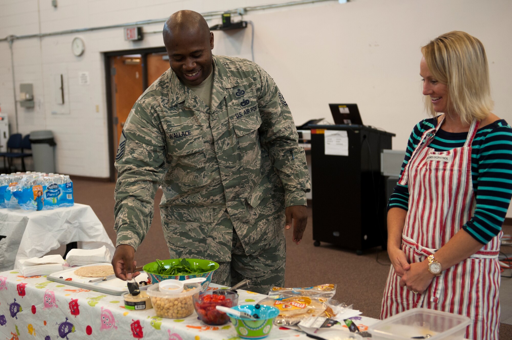 Erin Locke, 23d Medical Group health promotion dietitian, instructs U.S. Air Force Master Sgt. Marvin Wallace, 23d Wing Staff Agency first sergeant, on how to make a Mediterranean chick pea wrap during a healthy eating class for Super Sports Day Sept. 29, 2015, at Moody Air Force Base, Ga. Locke held the class as one of the activities for the Comprehensive Airmen Fitness portion of the day, focusing on the physical domain. (U.S. Air Force photo by Airman 1st Class Kathleen D. Bryant/Released)
