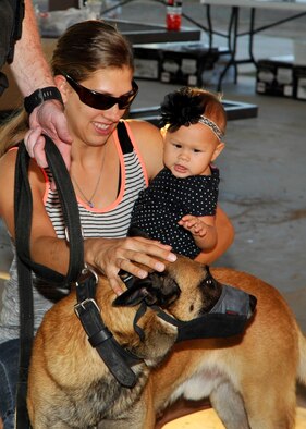 A mother pets a Glendale Police Department K-9 officer during the Deployed Family Day September 25, 2015, at Fowler Park on Luke Air Force Base, Arizona. The 56th FSS holds a monthly event for families who are remotely separated or separated by deployments. (U.S. Air Force photo by Staff Sgt. Marcy Copeland)