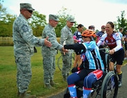 (From left to right) Chief Master Sgt. Paul G. Frisco Jr., 111th Attack Wing command chief, Michael Regan, Commander of the 111th ATKW's Mission Support Group, and Col. Howard Eissler, 111th ATKW  commander, high five cyclists participating in the Ride 2 Recovery's Army Navy Challenge as they pass through Newtown, Pennsylvania, on the third day of the week-long event. The affair raises money for injured veterans and began in New York City with and end point in Annapolis, Virginia. (U.S. Air National Guard photo by Tech. Sgt. Andria Allmond/Released)  
