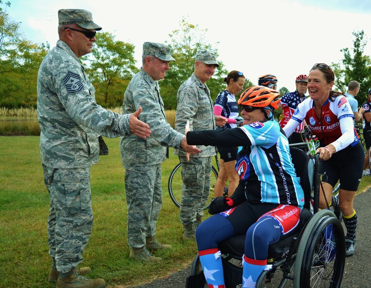 (From left to right) Chief Master Sgt. Paul G. Frisco Jr., 111th Attack Wing command chief, Michael Regan, Commander of the 111th ATKW's Mission Support Group, and Col. Howard Eissler, 111th ATKW  commander, high five cyclists participating in the Ride 2 Recovery's Army Navy Challenge as they pass through Newtown, Pennsylvania, on the third day of the week-long event. The affair raises money for injured veterans and began in New York City with and end point in Annapolis, Virginia. (U.S. Air National Guard photo by Tech. Sgt. Andria Allmond/Released)  