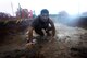 A U.S. Air Force Airman crawls through the mud during a 20th Fighter Wing Comprehensive Airman Fitness week obstacle course at Shaw Air Force Base, S.C., Sept. 25, 2015. Airmen were challenged throughout the event by a series of eight mud related obstacles meant to test the physical domain of CAF. (U.S. Air Force photo by Senior Airman Jensen Stidham/Released)