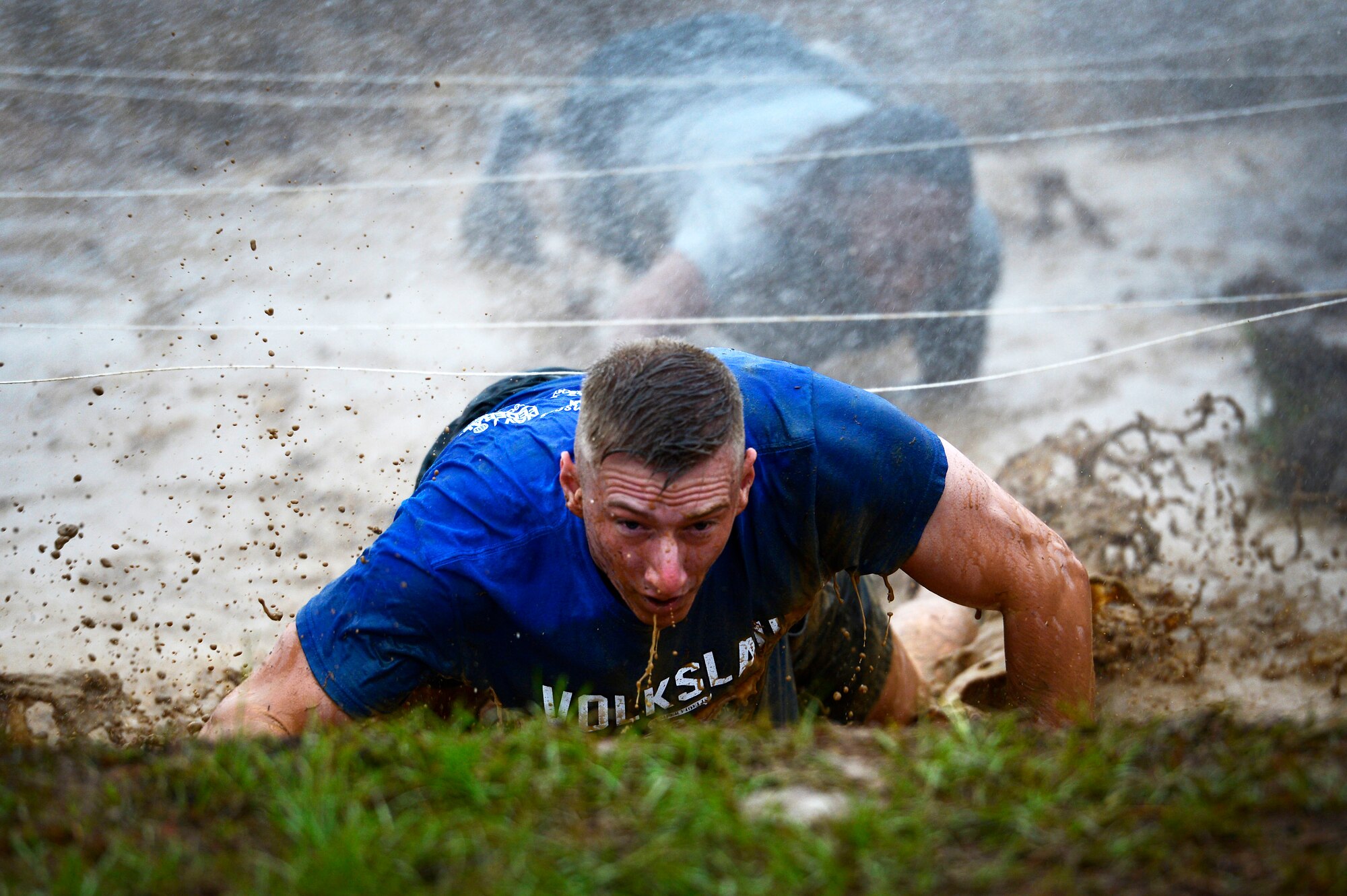 A U.S. Air Force Airman looks toward the end of a mud obstacle during a 20th Fighter Wing Comprehensive Airman Fitness week obstacle course at Shaw Air Force Base, S.C., Sept. 25, 2015. Airmen conquered the trench while being sprayed by a fire hose after previously accomplishing six obstacles. (U.S. Air Force photo by Senior Airman Jensen Stidham/Released)