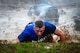 A U.S. Air Force Airman looks toward the end of a mud obstacle during a 20th Fighter Wing Comprehensive Airman Fitness week obstacle course at Shaw Air Force Base, S.C., Sept. 25, 2015. Airmen conquered the trench while being sprayed by a fire hose after previously accomplishing six obstacles. (U.S. Air Force photo by Senior Airman Jensen Stidham/Released)