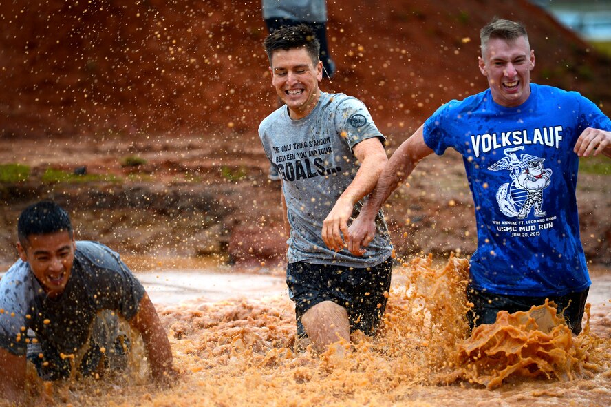 U.S. Air Force Airmen run through a mud pit during a 20th Fighter Wing Comprehensive Airman Fitness week obstacle course at Shaw Air Force Base, S.C., Sept. 25, 2015. Airmen were challenged throughout the event by a series of eight obstacles meant to test the physical domain of CAF. (U.S. Air Force photo by Senior Airman Jensen Stidham/Released)  