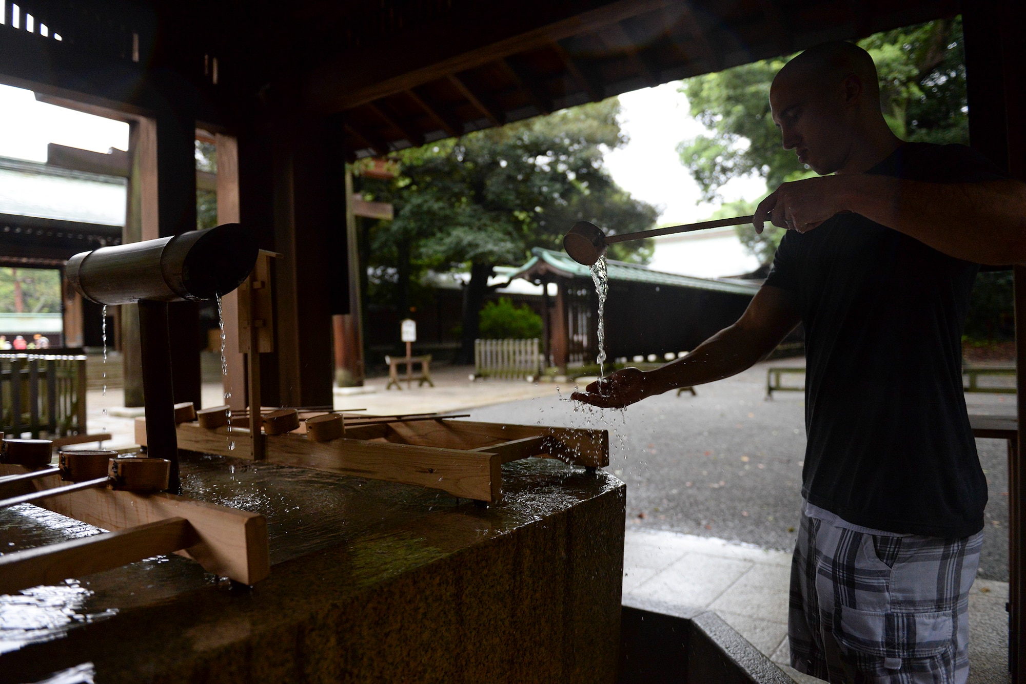 Staff Sgt. Zackary Webb, 374th Civil Engineer Squadron electrical systems craftsman, washes his hands before entering Meiji Shrine in Tokyo, Japan, Sept. 9, 2015. To pay respect at the shrine, visitors are asked to wash the left hand, then the right, the mouth and then the left hand again.  (U.S. Air Force photo by Airman 1st Class Elizabeth Baker/Released)