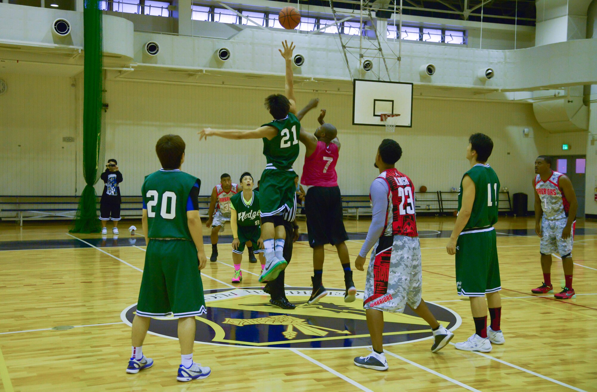 Alvin Holmes jumps for the ball at the beginning of a basketball game against the Saitama Hedges at Yokota Air Base, Japan, Sept. 26, 2015. The Hedges team won the tip, but were unable to score on their first possession. (U.S. Air Force photo by Senior Airman David Owsianka/Released)