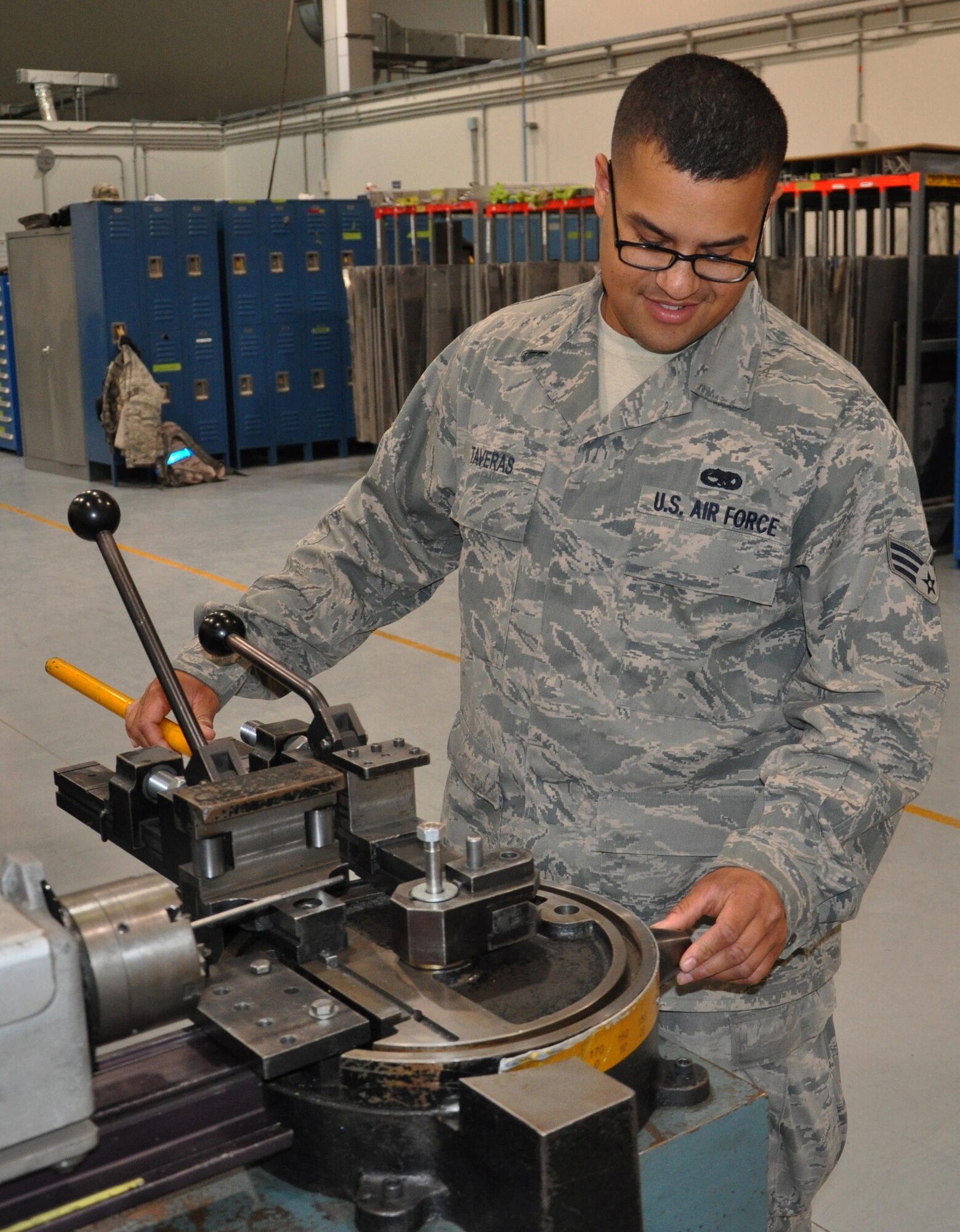 Senior Airman Emmanuel Taveras, 379th Expeditionary Maintenance Squadron electrical and environmental journeyman from Bronx, New York, looks at a tube bender at Al Udeid Air Base, Qatar March 16. Emmanuel deployed to AUAB in January joining his twin brother, Senior Airman Carlos Taveras, 379 EMXS aircraft structural maintenance apprentice, in the same deployed unit. The brothers said being deployed together at the same location is a dream come true. (U.S. Air Force photo by Tech. Sgt. James Hodgman/Released) 