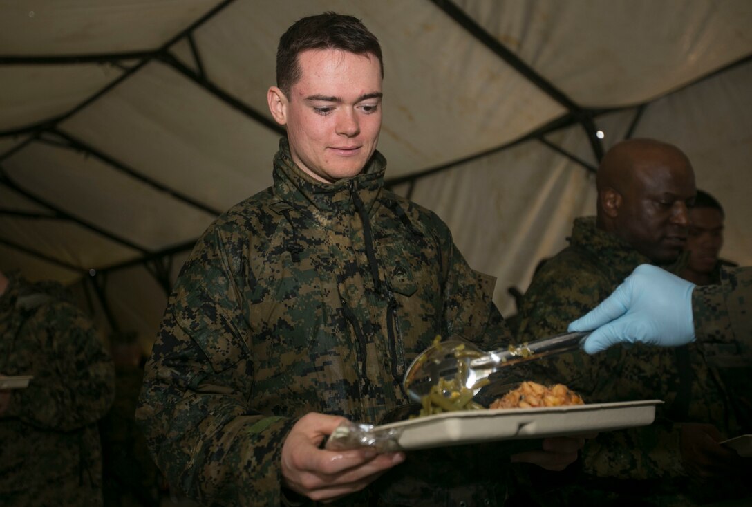 U.S. Marine Corps Cpl. Benjamin Hanks, a French horn player with III Marine Expeditionary Force Band, receives chow on Camp Hansen, Okinawa, Japan, Jan. 30, 2016. CPX 16 is conducted to improve the III MEF’s capabilities in intelligence and logistic operations, future planning, and combat readiness. (U.S. Marine Corps photo by MCIPAC Combat Camera Lance Cpl. Christian J. Robertson/Released)