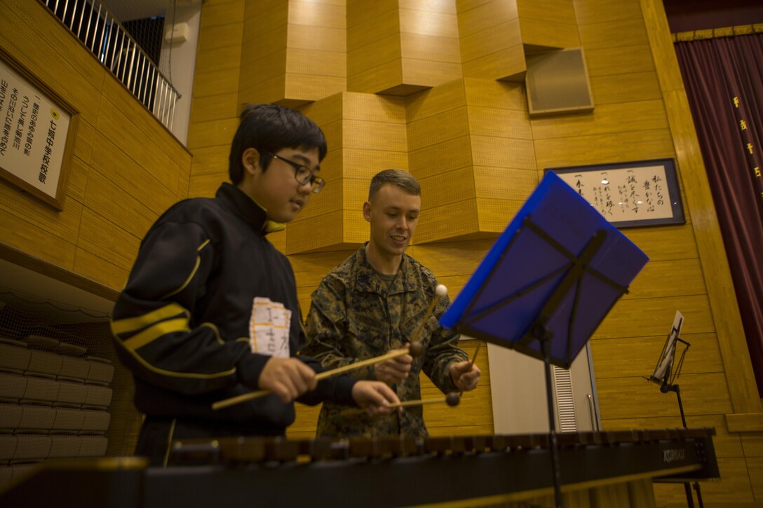 U.S. Marine Cpl. Ryan O. Vangosen instructs a student at Shichijo Junior High School, Kumamoto, Japan, Mar. 6. The Japan Ground Self-Defense Force Western Army Band and III Marine Expeditionary Force Band will perform with and  coach the students during their visit.The Marines were in Kumamoto to participate in the Western Army Band Music Festival, which celebrates the 60th Anniversary of the Western Army Band. (U.S. Marine Corps photo by Cpl. Tyler Ngiraswei/ Released)