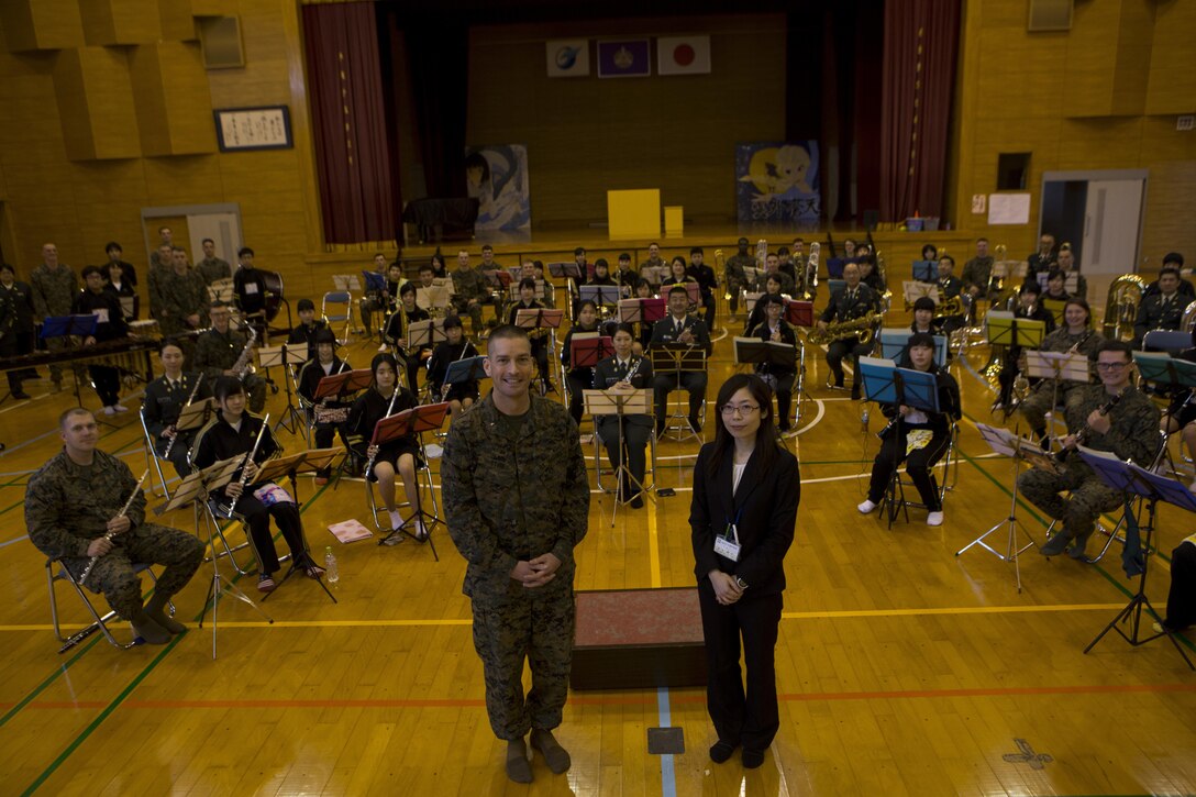 The III Marine Expeditionary Force Band, Japan Ground Self-Defense Force Western Army Band and Shichijo Junior High School Band pose for a photo Mar. 6, in the gymnasium at Shichijo Junior High School, Kumamoto, Japan. The Western Army Band and III MEF Band performed with and  coached the students during their visit.The Marines were in Kumamoto to participate in the Western Army Band Music Festival, which celebrates the 60th Anniversary of the Western Army Band. 